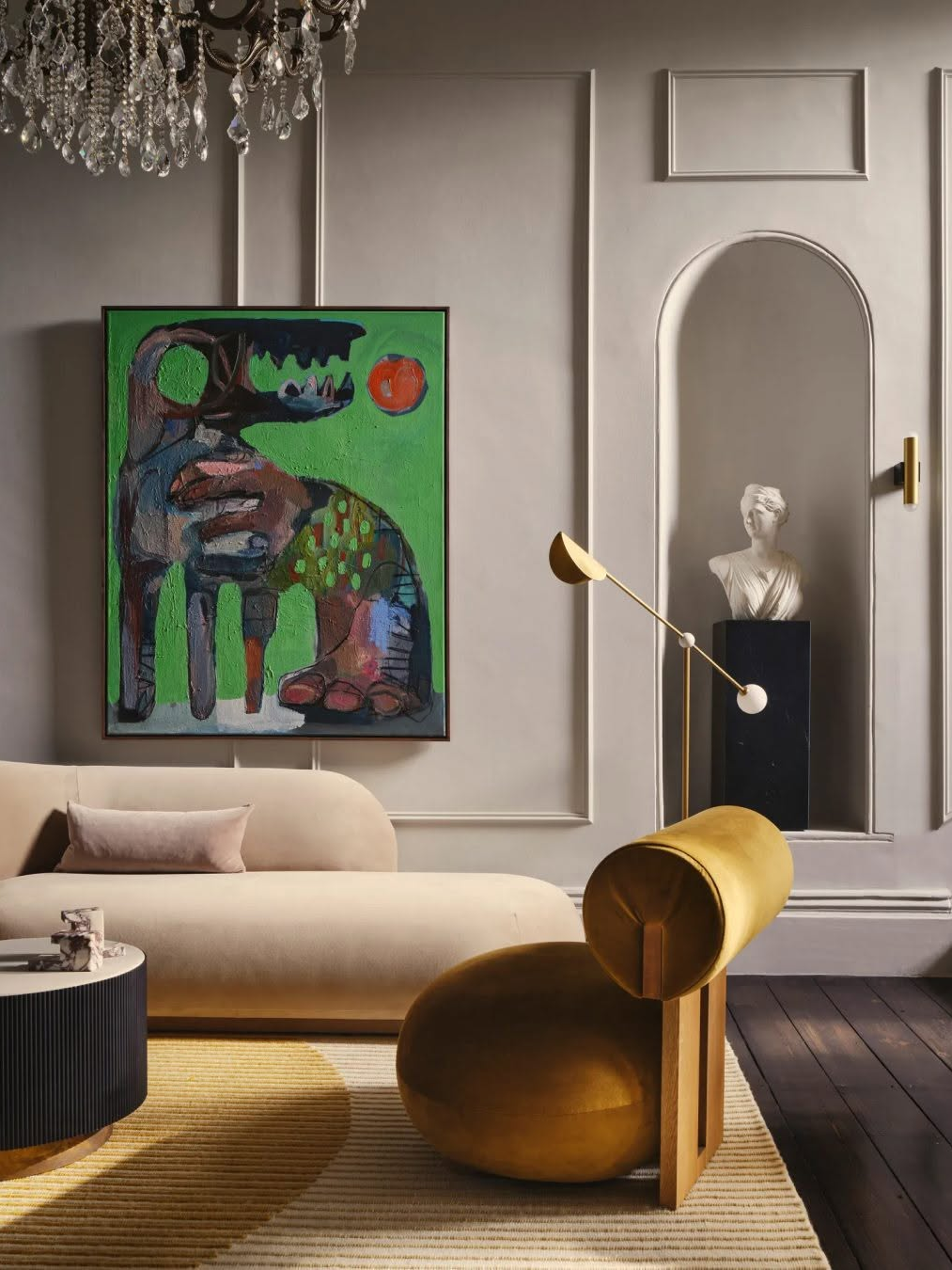 Sculptural living room with curved cream sofa, mustard accent chair, abstract artwork and soft neutral palette reflecting 2026 interior design trends