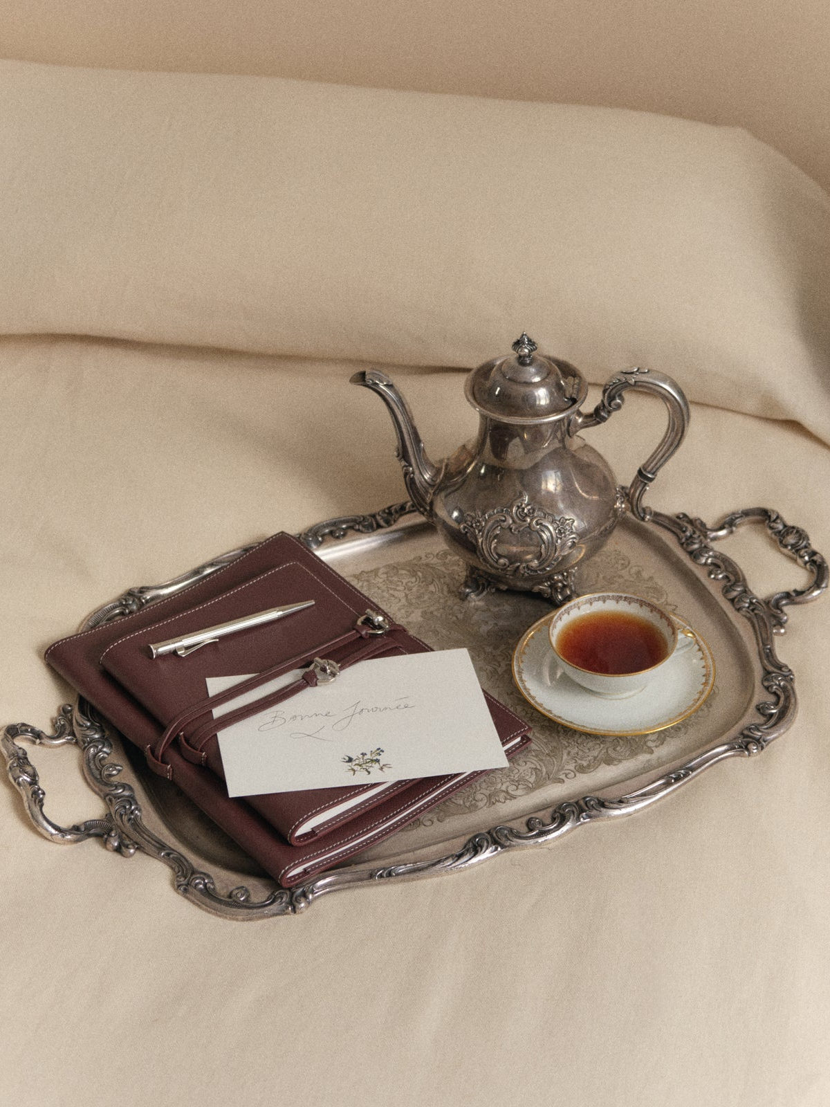 Campaign imagery from Rosie Huntington-Whiteley’s luxury gifting brand Mémoire featuring personalised leather journals, candlelit tablescapes and quiet luxury interiors.