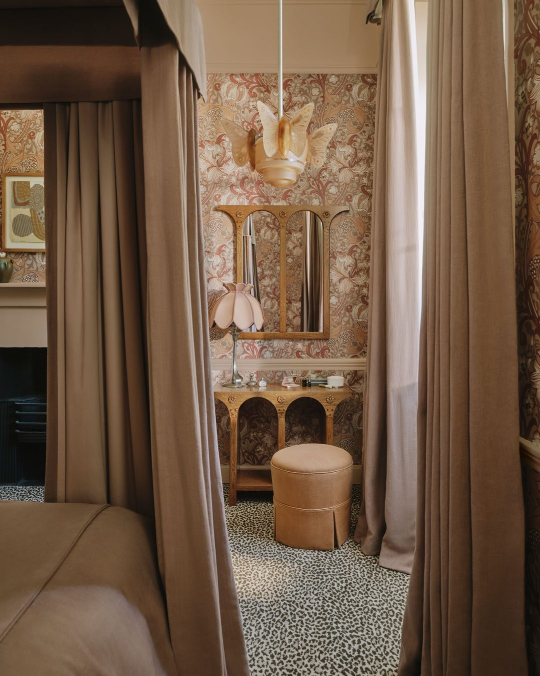 A dark botanical wallpaper hung across a full wall in a panelled room